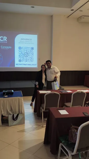 Ponente presentando frente a una pantalla en una sala de capacitación