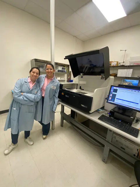 Dos especialistas junto a un analizador en el laboratorio